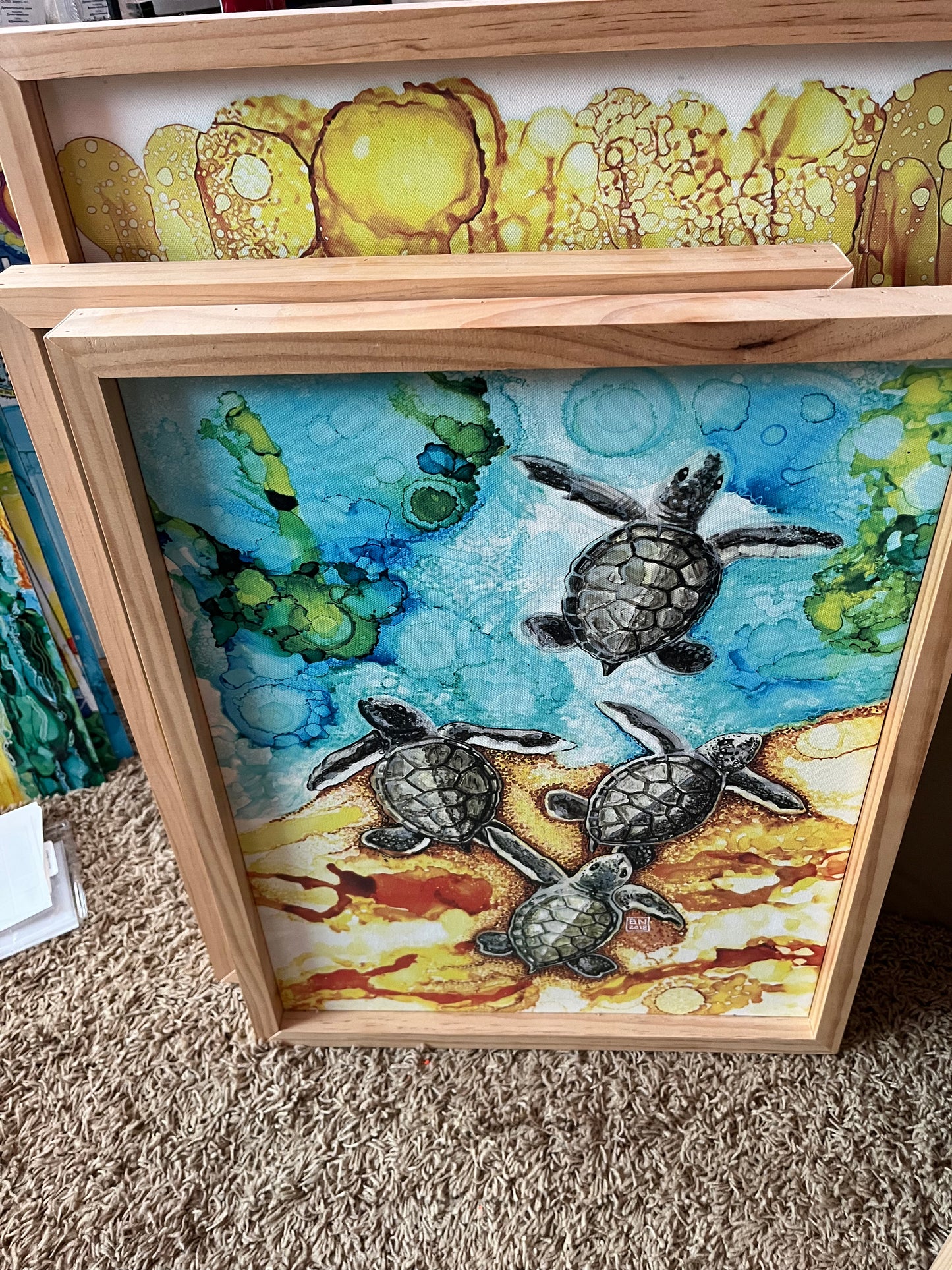 Baby Sea Turtles Entering the Ocean Canvas16" x 22" Baby Turtles Canvas Wood Framed Print of original alcohol ink painting by Barbara Newsome.  If you are a sea turtle fan, you will love this canvas print depicting 4 baby sea turtle hatch-lings making their way to the ocean and future. The painting was created using alcohol inks and pens. The print is framed with natural pine wood.. Barbara Newsome OBX Artist