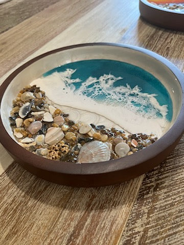 Beautifully decorated resin ocean waves inside this 10" round wooden serving tray, Dark wood with white swirls inside. Top half is pretty Teal Resin Ocean Waves crashing on real Outer Banks North Carolina sea shells. Collected from beaches on the OBX. 