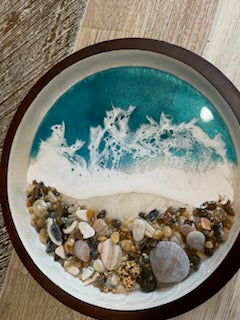 Beautifully decorated resin ocean waves inside this 10" round wooden serving tray, Dark wood with white swirls inside. Top half is pretty Teal Resin Ocean Waves crashing on real Outer Banks North Carolina sea shells. Collected from beaches on the OBX.  By Fyre Art Studio Kill Devil Hills NC OBX Resin Artist