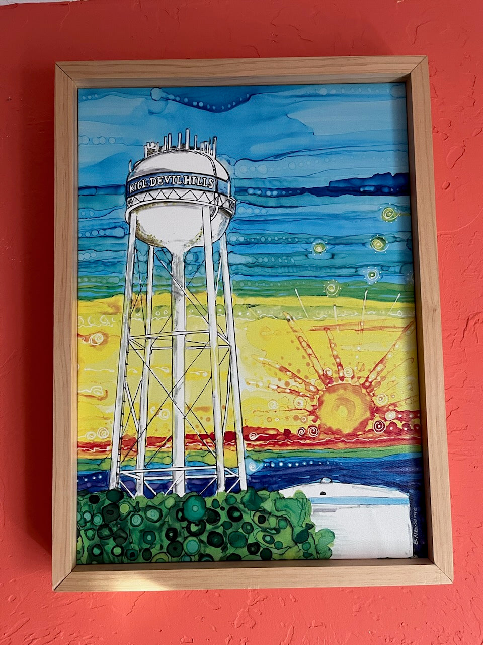 16" x 22" Kill Devil Hills Water Tower Canvas Framed Print of original alcohol ink painting by Barbara Newsome. Outer Banks North Carolina Water Tower Painting. This water tower was torn down several years ago and a newer one was erected.  This print is framed with natural pine wood for a clean beachy feel. The Kill Devil Hills NC water tower is at the center of Town. The water tower could be seen as you are traveled down Highway 158. 